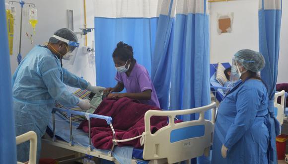 En esta imagen tomada el 1 de junio de 2021 un médico (centro) revisa a un paciente con coronavirus COVID-19 en una Unidad de Cuidados Intensivos (UCI) de un hospital de India. (Diptendu DUTTA / AFP).