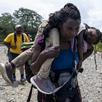 Una mujer migrante camina por la selva cargando a su hija cerca del pueblo de Bajo Chiquito, el primer control fronterizo de la provincia de Darién, en Panamá, el 22 de septiembre de 2023. (Foto de Luis ACOSTA/AFP).