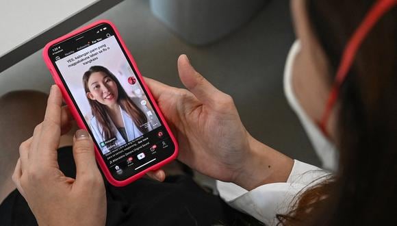 La reumatóloga Geraldine Zamora muestra uno de sus videos de TikTok en su teléfono inteligente durante una entrevista con AFP en un hospital de Manila, el 3 de noviembre de 2022. (Foto referencial de JAM STA ROSA / AFP)