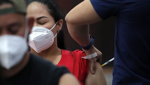 Una mujer recibe una dosis de la vacuna Pfizer-BioNTech contra el COVID-19 en un centro de vacunación de Santiago, el 20 de enero de 2022. (Foto de JAVIER TORRES / AFP)