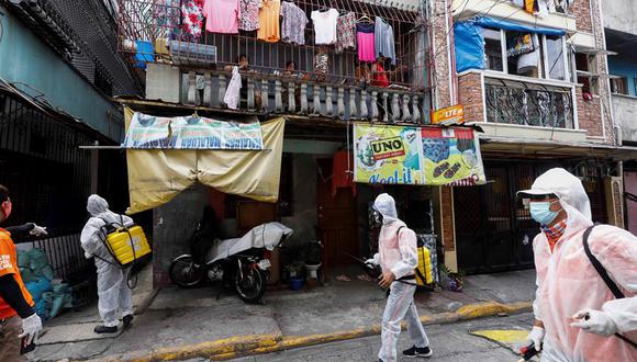 Trabajadores con trajes de protección desinfectan una calle de Manila. El presidente de Filipinas, Rodrigo Duterte, aprobó una nueva cuarentena para 27 millones de personas por el repunte del coronavirus. (EFE / EPA / ROLEX DELA PENA).