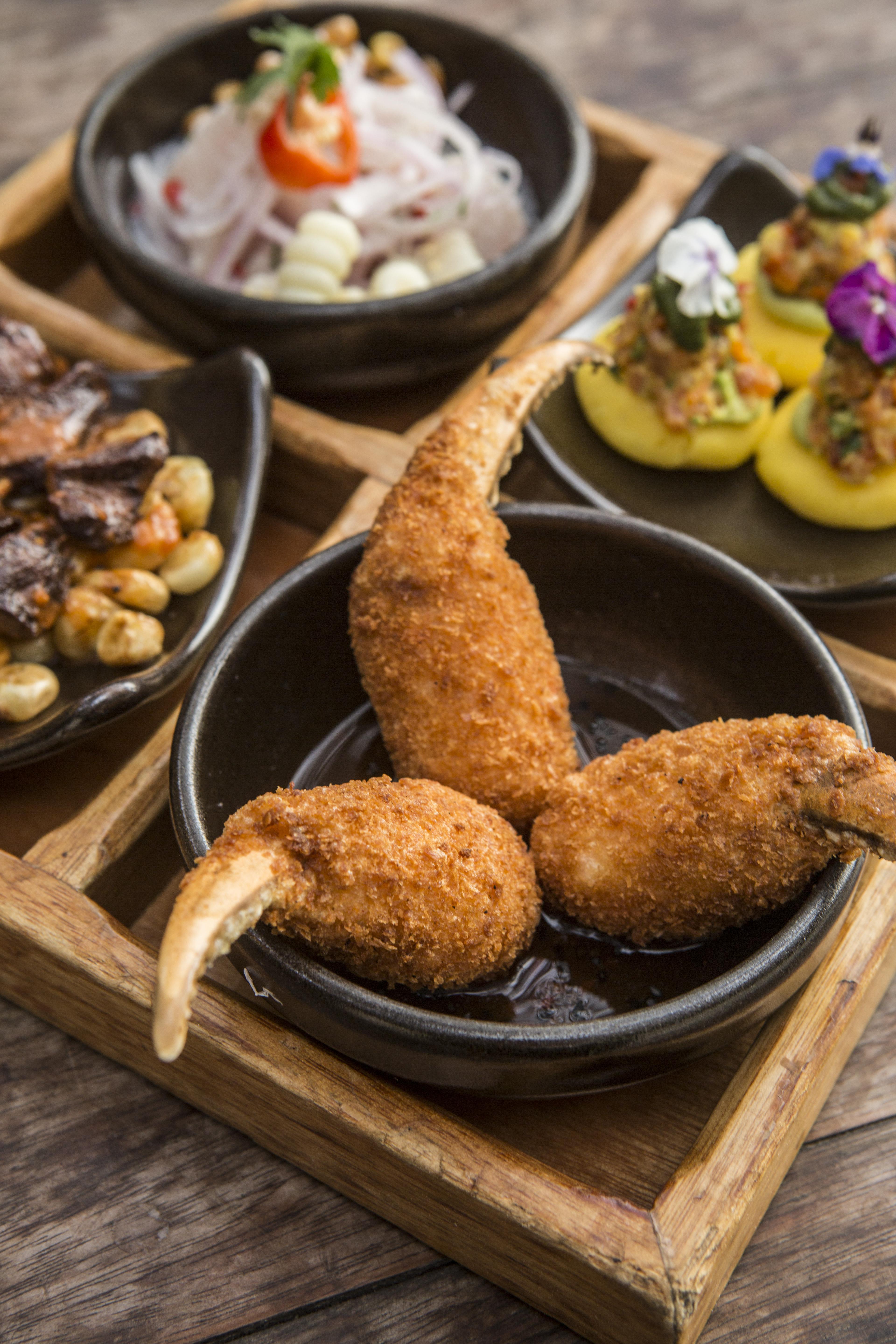 Tokapu con cuatro platos a elección. En la foto, anticuchos, causitas, cebiche y uñas de cangrejo.
