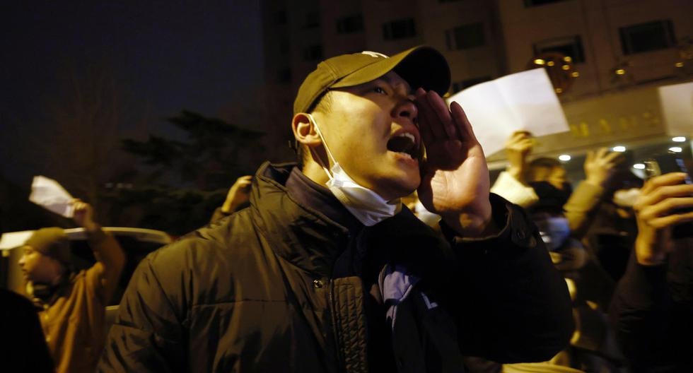 Los manifestantes gritan mientras sostienen papeles en blanco durante una protesta en Beijing provocada por un incendio en Urumqi, que mató a 10 personas en medio de las restricciones por coronavirus en China. (EFE/EPA/MARK R. CRISTINO).