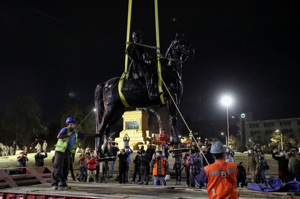 La estatua del general Manuel Baquedano, ubicada en el epicentro de las protestas en Chile, la Plaza Italia, y que ha sido objeto de numerosos ataques, fue removida en la madrugada de este viernes para su restauración. (Texto: EFE / Foto: Reuters).