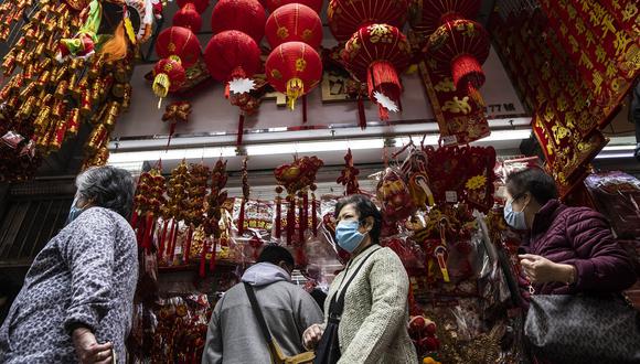 La gente mira las decoraciones a la venta en Hong Kong el 12 de enero de 2023 antes del Año Nuevo Lunar del Conejo, que cae el 22 de enero. (Foto referencial de ISAAC LAWRENCE / AFP)