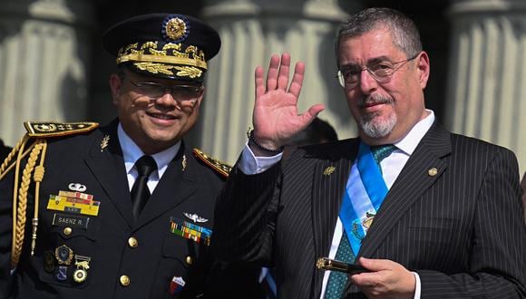 El presidente de Guatemala, Bernardo Arévalo, saluda junto al ministro de Defensa, Henry Sáenz, frente al Palacio Nacional de Cultura en la Ciudad de Guatemala, el 15 de enero de 2024. (Foto de Johan ORDONEZ / AFP)