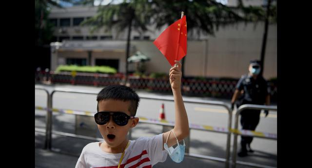 Un niño agita una bandera de su país frente al consulado de Estados Unidos En Chengdu, provincia de Sichuan. (Foto: Noel Celis / AFP).