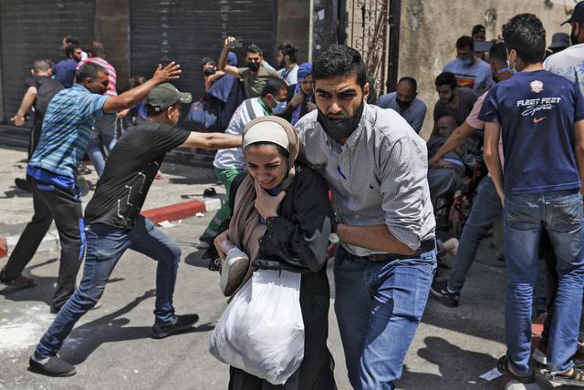 Los palestinos evacuan un edificio atacado por Israel en la ciudad de Gaza el 11 de mayo de 2021. (Foto de MAHMUD HAMS / AFP).