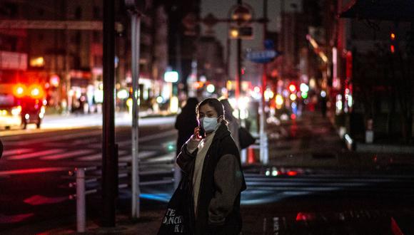 Una mujer habla por teléfono en la calle de una zona residencial durante un corte de energía en Tokio, Japón, tras el terremoto de magnitud 7,4. (PHILIP FONG / AFP).