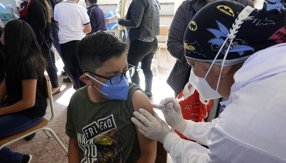 Una trabajadora de salud vacuna a un niño contra el COVID-19 en una escuela de Quito el 18 de octubre de 2021, cuando Ecuador comenzó a inocular a niños de 5 a más de 11 años. (Foto: RODRIGO BUENDIA / AFP).