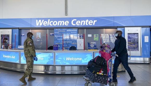 El personal militar habla con los viajeros cuando llegan a la terminal 4 del aeropuerto internacional JFK, en Nueva York (Estados Unidos), el 22 de diciembre de 2020. (Kena Betancur / AFP).