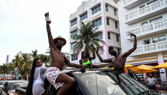 La gente disfruta mientras conduce por Ocean Drive, en Miami Beach, Florida, el 14 de julio de 2020, en medio de la pandemia de coronavirus. (Foto de CHANDAN KHANNA / AFP).