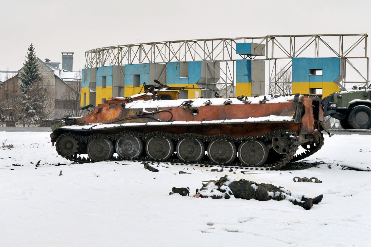 The body of a Russian serviceman lies near destroyed Russian military vehicles on the roadside on the outskirts of Kharkiv, Ukraine, on February 26, 2022. (SERGEY BOBOK / AFP)