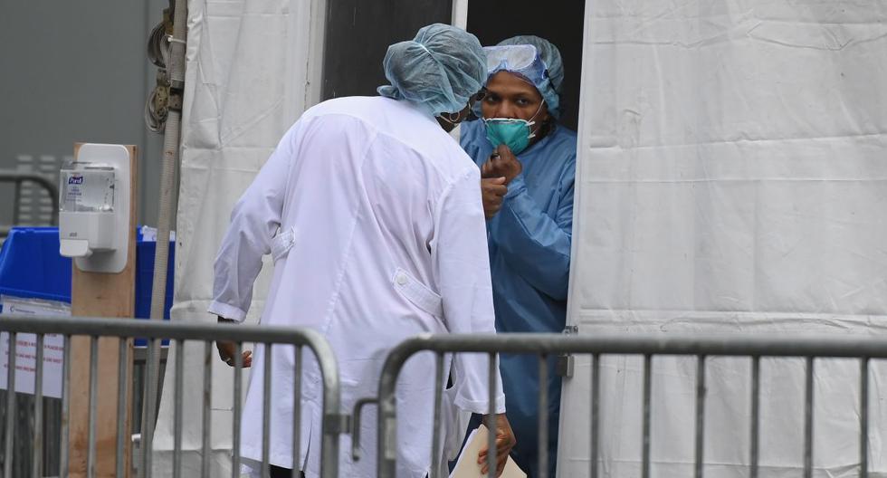 Personal médico que atiende la emergencia del coronavirus en Nueva York habla afuera de una carpa de detección COVID-19 instalada en el Brooklyn Hospital. (AFP/Angela Weiss).