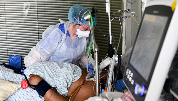 Una trabajadora sanitaria atiende a un paciente de coronavirus en la unidad de cuidados intensivos de un hispital de París, Francia. (Foto de ALAIN JOCARD / AFP).