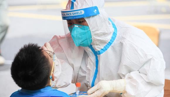 Un niño es sometido a una prueba de COVID-19 en China. (Photo by STR / AFP)