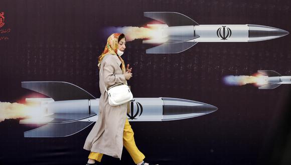 Una mujer iraní pasa junto a una enorme pancarta antiisraelí con imágenes de misiles, en Teherán, Irán, el 19 de abril de 2024. (EFE/EPA/ABEDIN TAHERKENAREH).