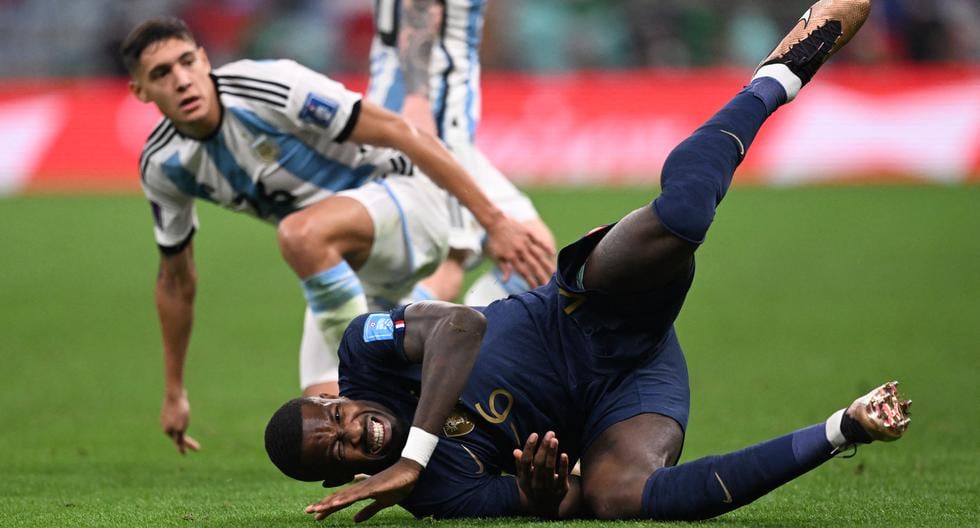 France's forward #26 Marcus Thuram (R) falls on the pitch after being tackled by Argentina's defender #26 Nahuel Molina during the Qatar 2022 World Cup final football match between Argentina and France at Lusail Stadium in Lusail, north of Doha on December 18, 2022. (Photo by Kirill KUDRYAVTSEV / AFP)