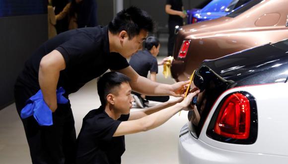 Trabajadores preparan la exposición de un Rolls-Royce para el Salón del Automóvil de Shangái. (Foto: EFE)