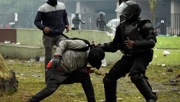 Un policía antidisturbios forcejea con un manifestante durante enfrentamientos en el parque El Ejido, en Quito, Ecuador, el 24 de junio de 2022. (RODRIGO BUENDIA / AFP).