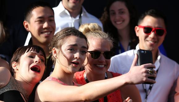 "Game of Thrones". Maisie Williams mientras se toma fotos con fans que asistieron a la premiere de la quinta temporada de la serie en 2015. Foto: AFP.