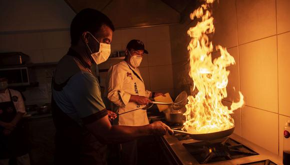 Julio Cesar Uribe al wok y su lado, el chef Carlos Acuna, ambos, socios del Jova Grill, el nuevo restaurante de carnes donde el mismo crack de la selección del 81 cocina. FOTO: Elías Alfageme.