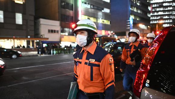 Los bomberos trabajan fuera de un edificio de oficinas donde se produjo un incendio en Osaka el 17 de diciembre de 2021. (Foto de Philip FONG / AFP)