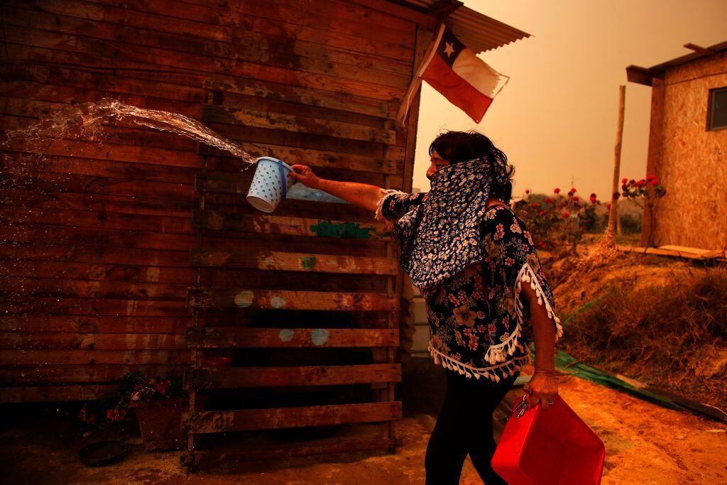 A woman tries to put out a fire in the commune of Quilpe, in Valparaíso.  (AFP/GETTY).