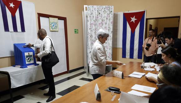 Dos personas votan en las elecciones parlamentarias, en un colegio electoral de La Habana, Cuba. (Foto de Ernesto Mastrascusa / EFE)