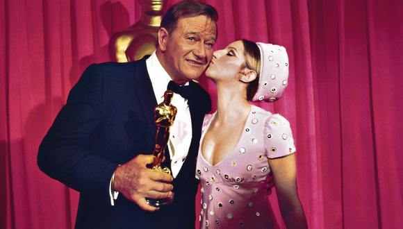 John Wayne recibe el Óscar a Mejor Actor, en 1970, por su rol en “Temple de acero”. El anuncio lo hizo  una veinteañera Barbra Streisand. (Foto: Bettmann)