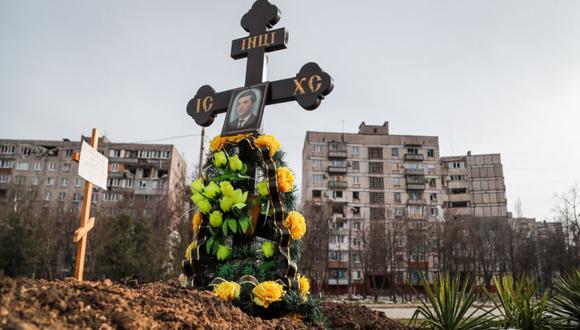 Las tumbas de los civiles muertos durante el conflicto entre Ucrania y Rusia se ven junto a edificios de apartamentos en la ciudad portuaria de Mariupol, Ucrania.