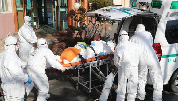 Los trabajadores médicos usan equipos de protección para transferir a un paciente sospechoso de coronavirus a otro hospital desde el Hospital Daenam, en el condado de Cheongdo, cerca de la ciudad de Daegu, en el sureste de Corea del Sur (Foto: AFP)