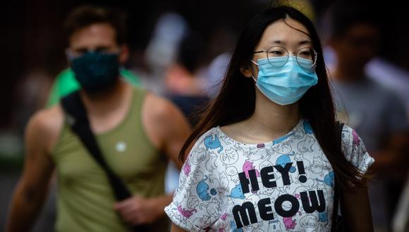 Las personas usan mascarillas mientras caminan por el Queen Street Mall en Brisbane, en medio de la pandemia de coronavirus en el Reino Unido. (Foto de Patrick HAMILTON / AFP).