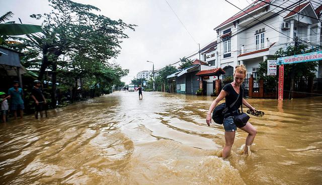 EPA2970. HOI AN (VIETNAM), 06/11/2017.- Una mujer camina por las calles inundadas de Hoi An (Vietnam) hoy, 6 de noviembre de 2017. Al menos 27 personas murieron y otras 22 se encuentran desaparecidas debido a las fuertes lluvias e inundaciones causadas por el tifÛn Damrey en la zona central de Vietnam. EFE/ Wallace Woon