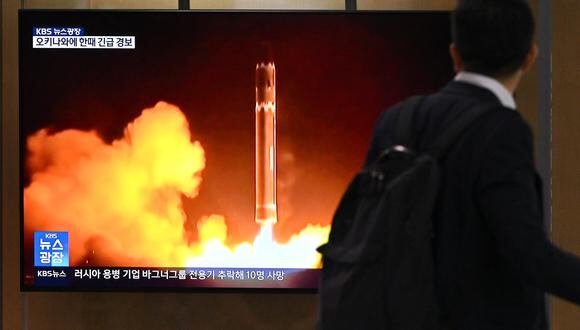 Un hombre pasa junto a una pantalla de televisión que muestra una transmisión de noticias con imágenes de archivo de una prueba de misiles norcoreanos. (Foto: Jung Yeon-je / AFP)