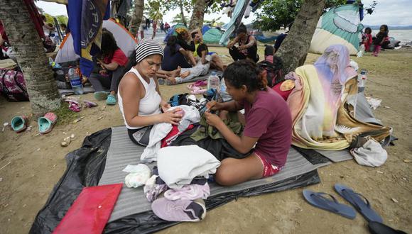 Migrantes venezolanos descansan en la playa mientras esperan un bote para dirigirse a Acandí desde Necoclí, Colombia.