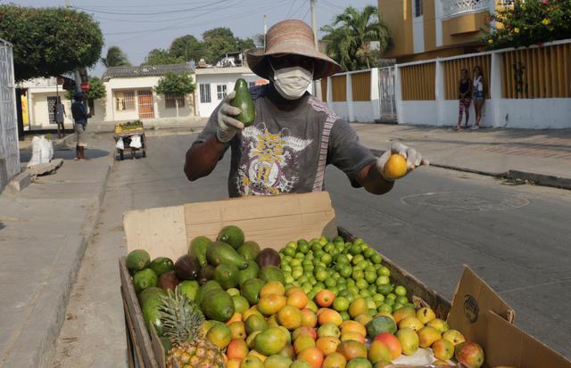 Un hombre vende frutas pese a las restricciones impuestas para prevenir el contagio de COVID-19 en Cartagena. (EFE/Ricardo Maldonado Rozo).
