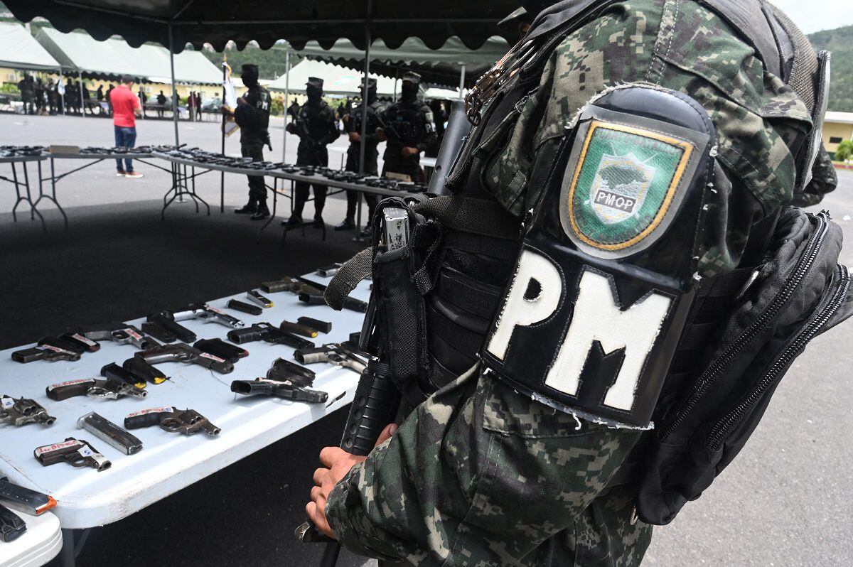 Members of the Public Order Military Police (PMOP) guard the arsenal seized from the Barrio 18 and Mara Salvatrucha (MS-13) gangs, in the village of Las Pozas in Tegucigalpa on July 10, 2023. (Photo by Orlando SIERRA / AFP)