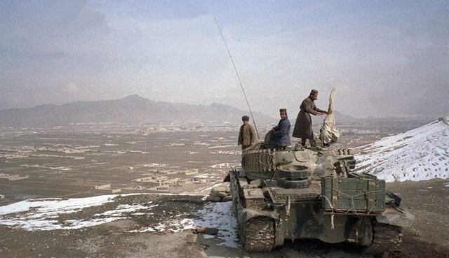 Los soldados afganos se colocaron en la cima del tanque con vista al aeropuerto de Kabul desde las colinas que rodean la ciudad cuando la Unión Soviética completó su retiro total del país el 15 de febrero de 1989. (AFP)