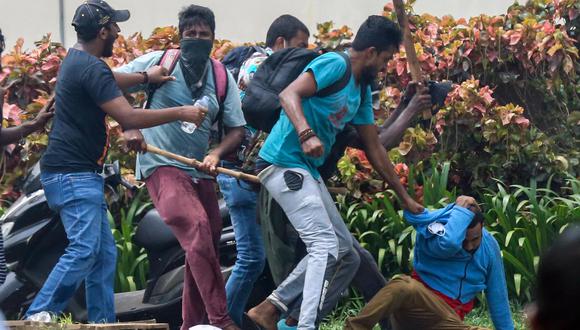 Simpatizantes del gobierno golpean a un manifestante opositor durante los enfrentamientos cerca de la casa del primer ministro en Colombo, Sri Lanka, el 9 de mayo de 2022. (EFE/EPA/CHAMILA KARUNARATHNE).