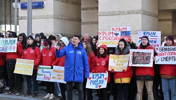 Jóvenes activistas a favor del Kremlin asisten a una manifestación frente a la embajada británica en Moscú el 18 de marzo de 2023. (Foto de Yuri KADOBNOV / AFP)