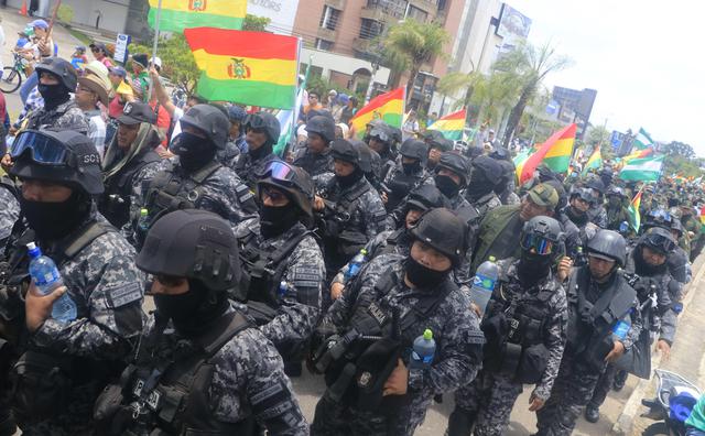 Un grupo de policías ondea la bandera tricolor de Bolivia mientras marcha en Santa Cruz junto a la población que exigen la renuncia de Evo Morales. (EFE/Juan Carlos Torrejón).
