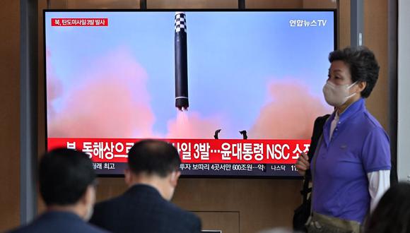 La gente mira una pantalla de televisión que muestra una transmisión de noticias con imágenes de archivo de una prueba de misiles de Corea del Norte, en una estación de tren en Seúl el 25 de mayo de 2022. (JUNG YEON-JE / AFP).