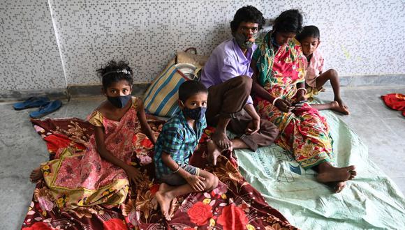 Los aldeanos descansan en un refugio mientras el ciclón Yaas avanza hacia la costa este de la India, en la Bahía de Bengala. (Foto de Dibyangshu SARKAR / AFP).