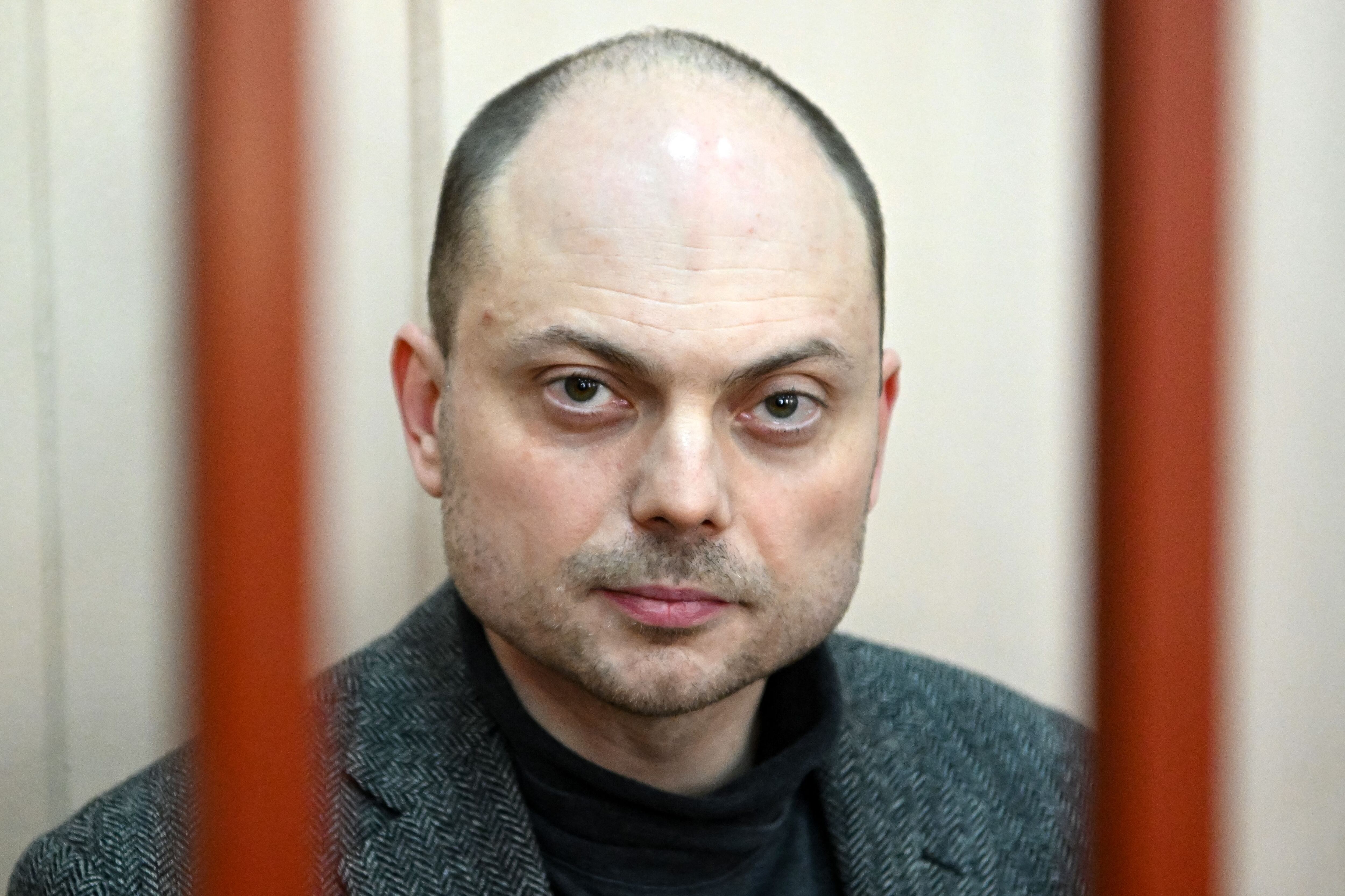 Russian opposition activist Vladimir Kara-Murza sits on a bench inside the defendants' cage during a hearing at the Basmanny court in Moscow on October 10, 2022. (Photo by NATALIA KOLESNIKOVA/AFP).