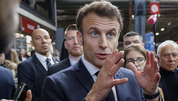 El presidente de Francia, Emmanuel Macron (C), hace un gesto mientras visita la 59ª edición de la feria agrícola en su día de inauguración en París el 25 de febrero de 2023. (Foto de Ludovic MARIN / POOL / AFP)