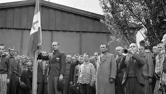 Prisioneros franceses izan la bandera de la Francia libre con la cruz de Lorena, el 29 de abril de 1945, tras la liberación del campo de concentración nazi de Dachau, cerca de Munich por los Aliados. (Foto de ERIC SCHWAB / AFP)