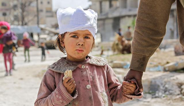 TOPSHOT - A wounded Syrian girl walks with her parents in the town of Kfar Batna, Southeastern Ghouta, on the eastern outskirts of the capital Damascus, on March 19, 2018. Since it began a month ago, the offensive has killed more than 1,400 civilians in Ghouta, according to the Syrian Observatory for the Human Rights monitor. / AFP / STR