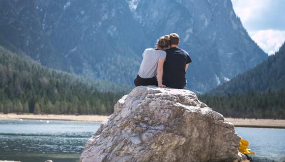 Unos novios disfrutando la vista de un lago. | Imagen referencial: Timo Stern / Unsplash
