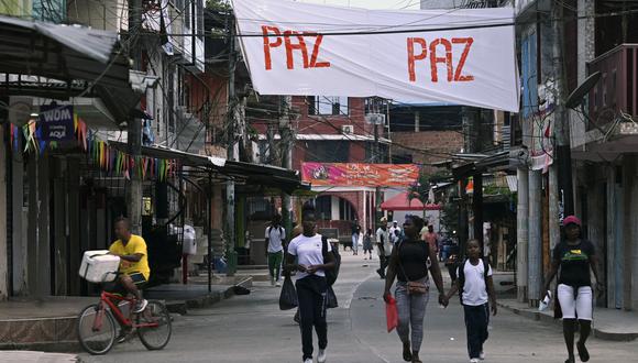 Personas caminan junto a una pancarta que dice "Paz" en la localidad de El Charco, en el municipio del mismo nombre en el departamento colombiano de Nariño, el 3 de marzo de 2023. (Foto de Joaquín SARMIENTO / AFP)